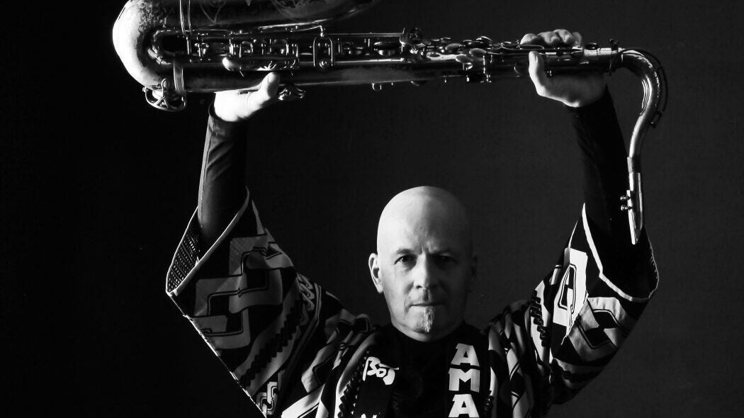 Man holding a tenor saxophone above his head