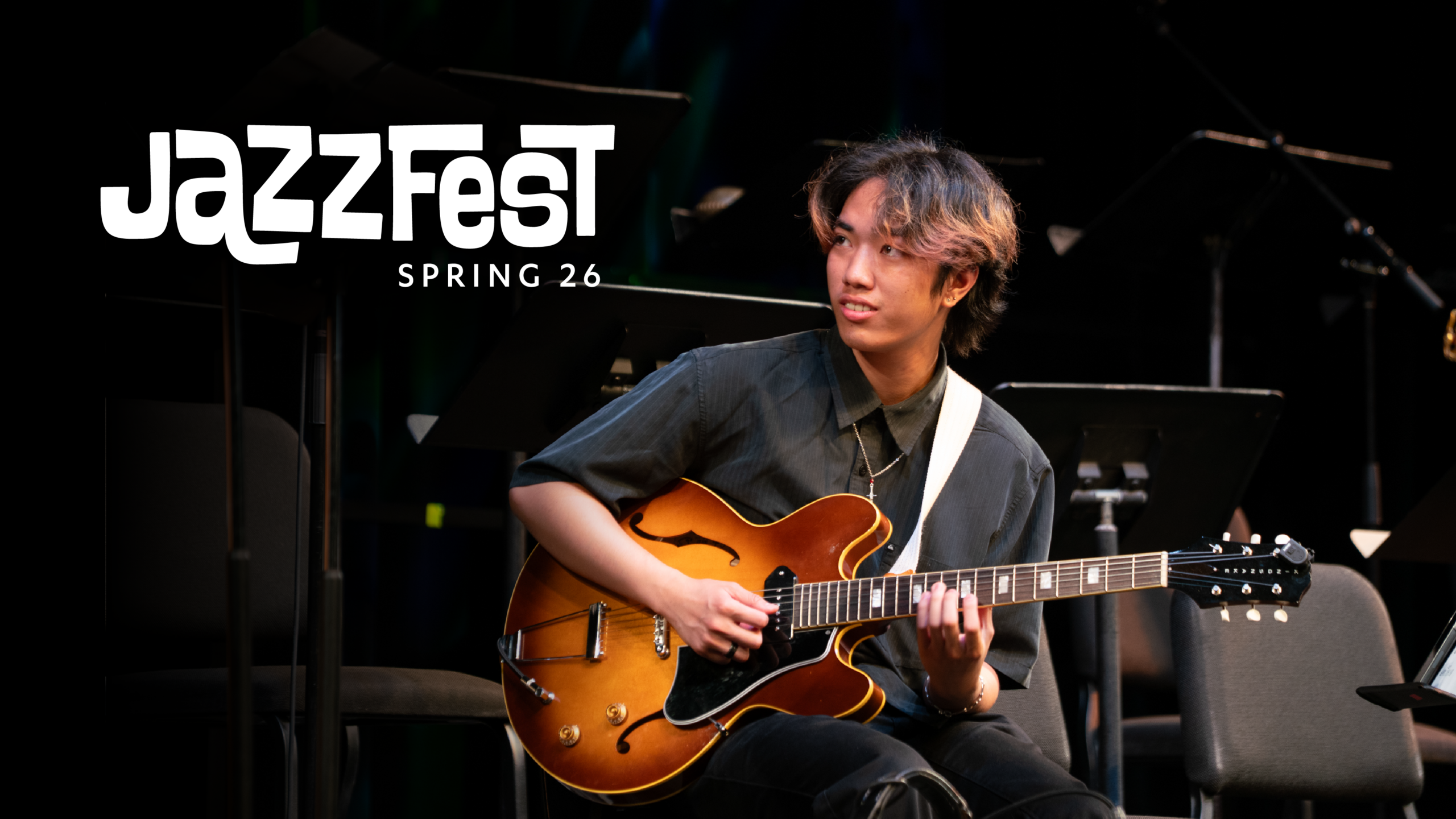 man playing a guitar against a black background and the words Jazzzfest Winter 26 in graphic text.