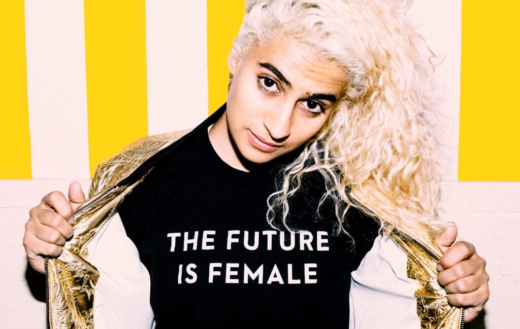 South Asian woman with bleached blonde hair in a black t shirt that reads The Future is Female.