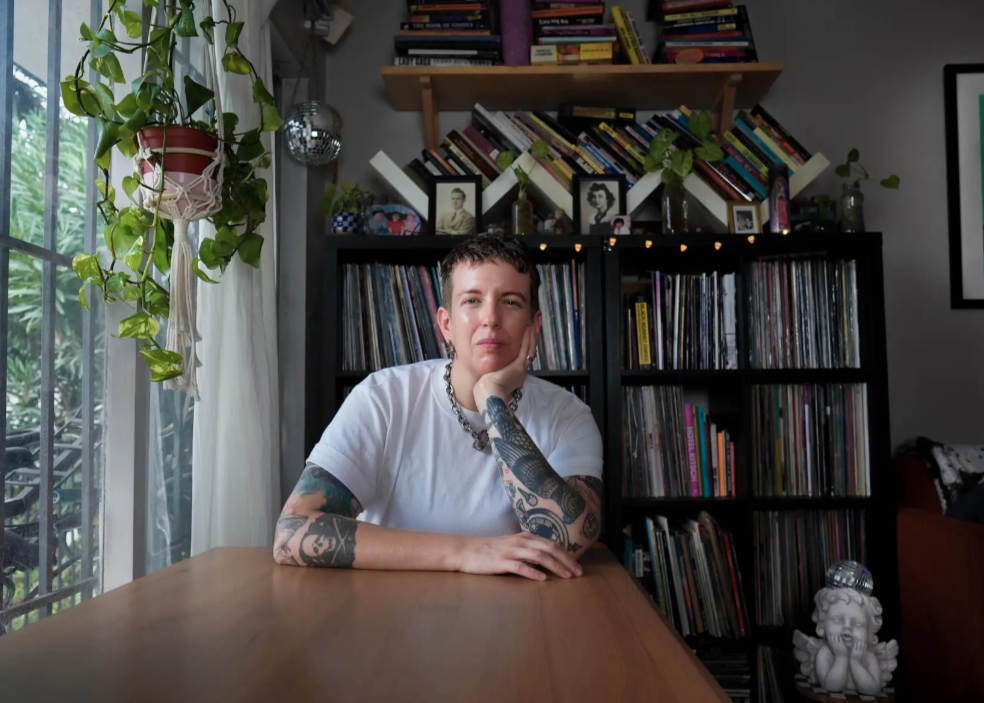 Candace Hansen sits at a table in the middle of a room.