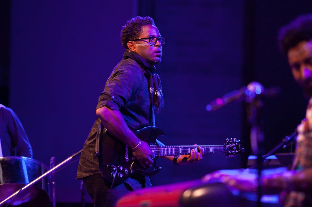 Man playing guitar on stage.