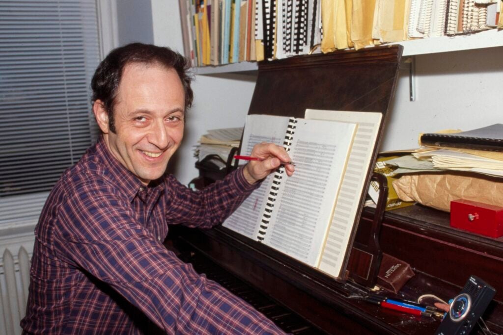 Man sitting at a piano and looking at camera.